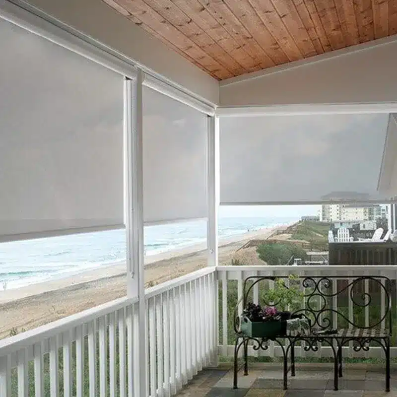 Porch with Solar Shades Overlooking the Beach Covered porch with white solar shades providing shade and privacy while overlooking a scenic beach view