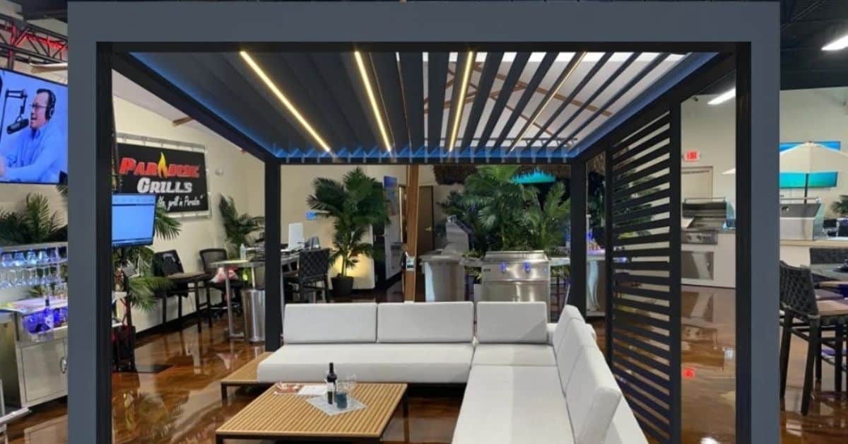 Outdoor lounge area under a motorized louvered pergola with seating and lighting