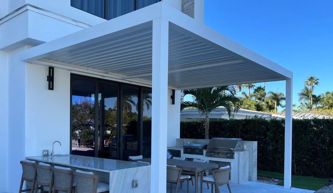 White aluminum pergola installed over an outdoor kitchen and dining area in Florida