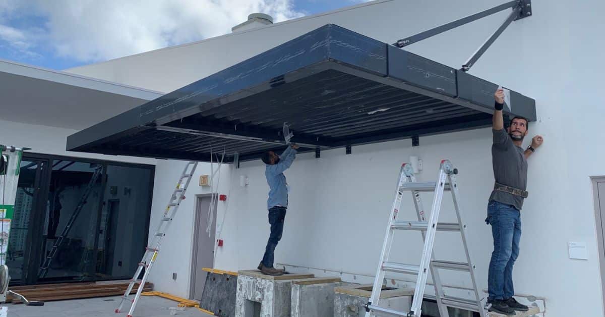 Team installing a modern louvered roof pergola on a Florida property